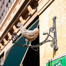 Load image into Gallery viewer, Decorative metal rooster on a building facade with a blurred background
